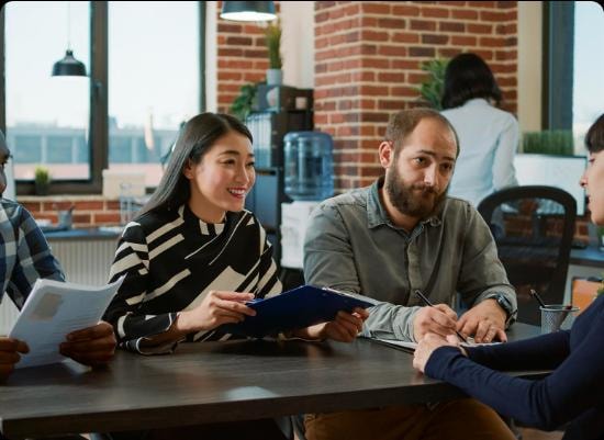 Consultants reviewing documents with a client at a meeting table